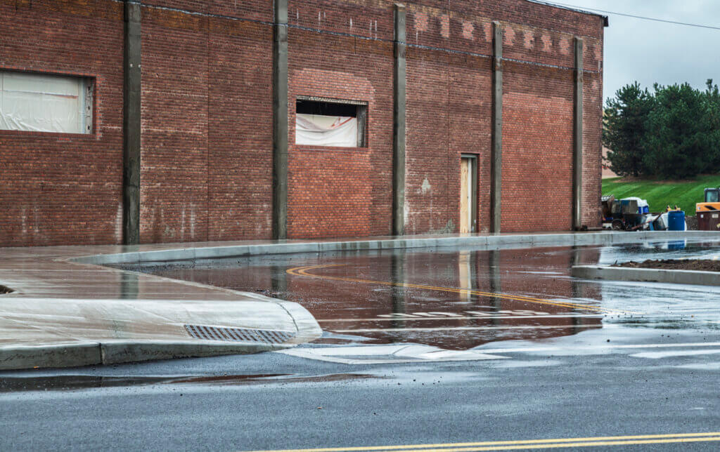 Rain Water Puddles On Retail Shopping Parking Lot Access Road